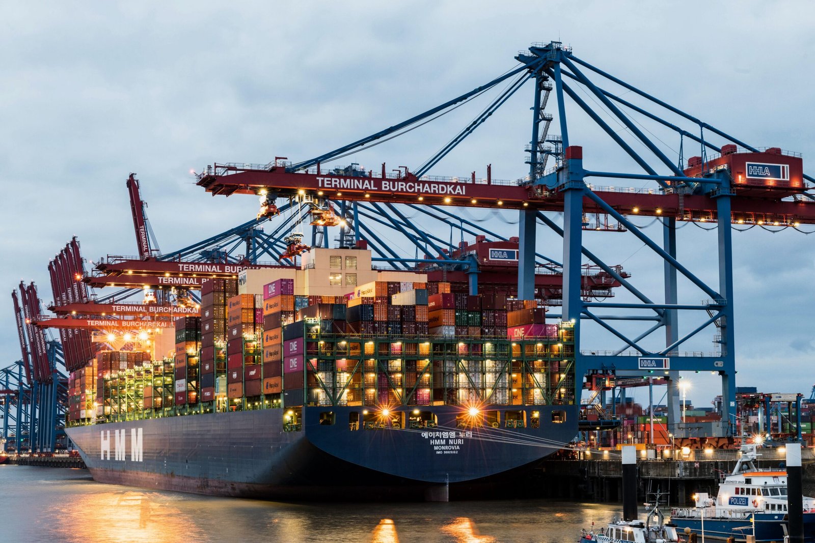 Projects 3 Container ship at Hamburg Terminal Burchardkai with cranes at twilight.