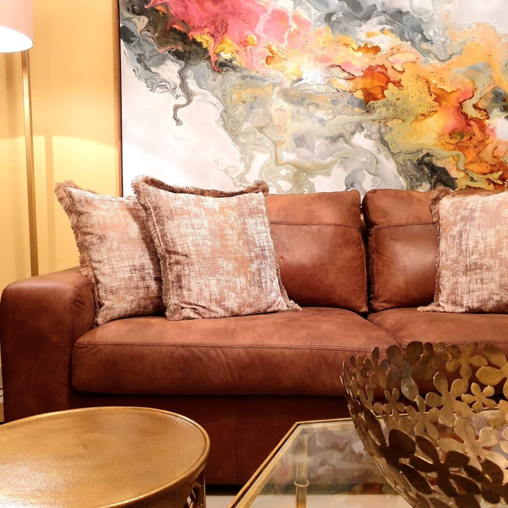 Warm home interior with brown leather sofa and abstract painting.